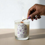 Hand lighting a scented sea salt orchid candle.