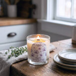 Sea salt and orchid candle on wooden table with herbs