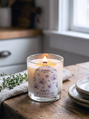 Sea salt and orchid candle on wooden table with herbs