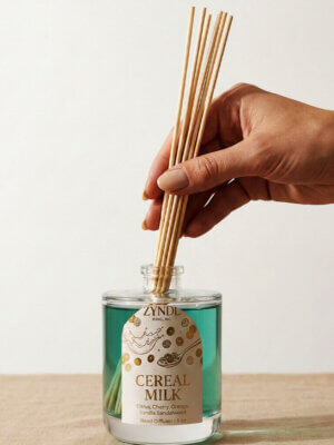 Hand placing reeds in diffuser bottle