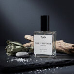 iced bergamot and driftwood Fragrance bottle with natural elements.