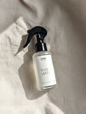mango and coconut milk room spray bottle on a light fabric