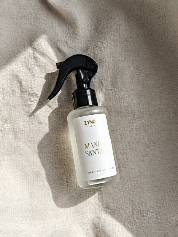 mango and coconut milk room spray bottle on a light fabric
