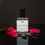 rosewood perfume bottle with rose petals.