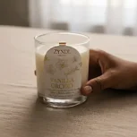 Hand holding vanilla orchid candle