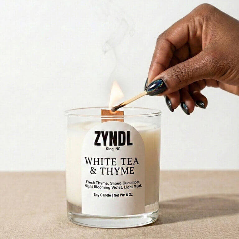 Hand lighting white tea candle.